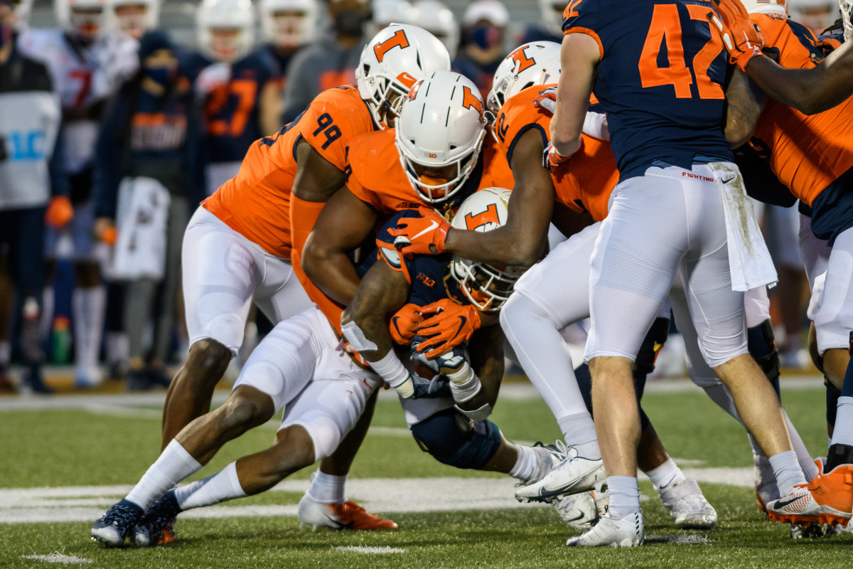Illinois outside linebacker Owen Carney Jr. (99) and defensive end Jer’Zhan Newton (94) combine for a tackle during the 2021 spring game on April 19, 2021. 